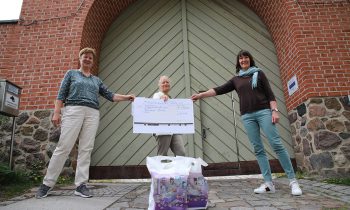 Die beiden Bibliotheksmitarbeiterinnen Roswitha Ackermann (links) und Petra Kather (rechts) nehmen den Spendenscheck von Barbara Hink entgegen. Foto: Marcel Gäding
