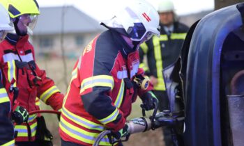 Mit einer hydraulisch betriebenen Schere verschafft sich ein Feuerwehrmann Zugang zum verunfallten Fahrzeug. Foto: Marcel Gäding